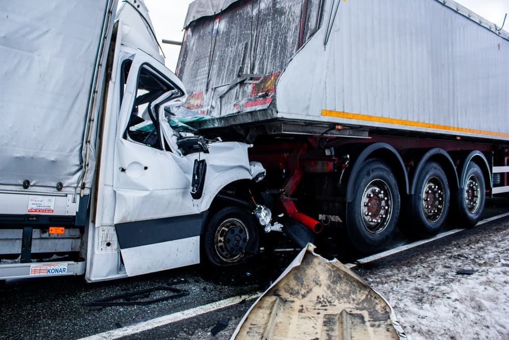 Accident of a delivery van and a truck. The car hit the back of the truck