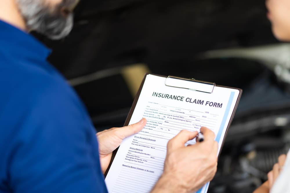 a person filling out car accident claim form