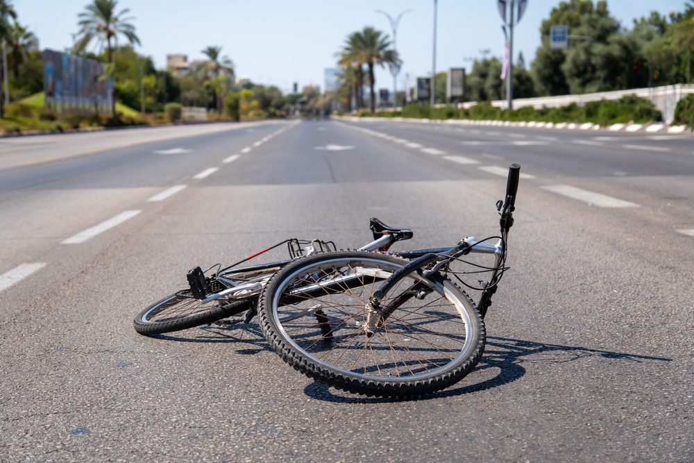 Bicycle lying on a city road in summer day. Road accident