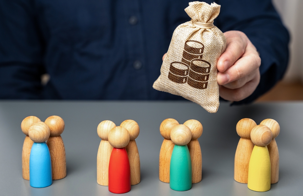 A hand holds a money bag while wooden figures symbolize families, representing accountability for funds.